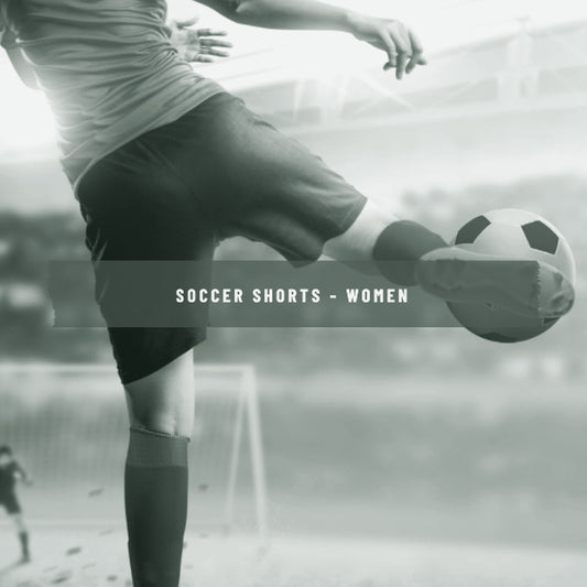 Woman kicking a soccer ball on the field wearing red socks and shorts, ThreaderPros women's custom soccer shorts