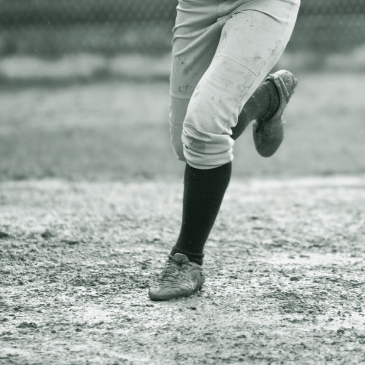 Softball player in white and red uniform pants sliding into base, ThreaderPros custom softball pants